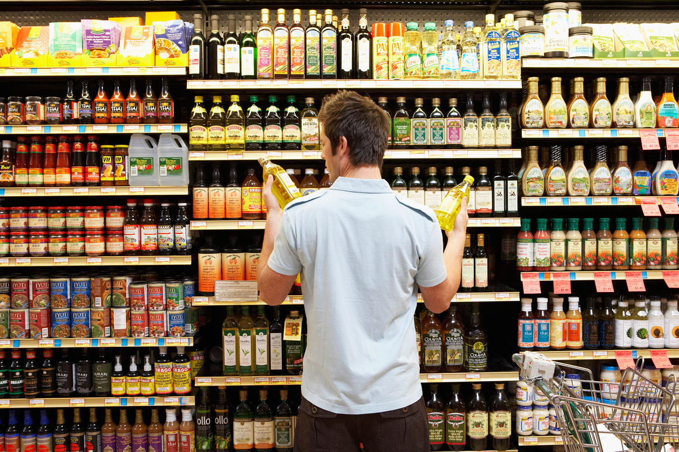 Man examining product packaging at a supermarket